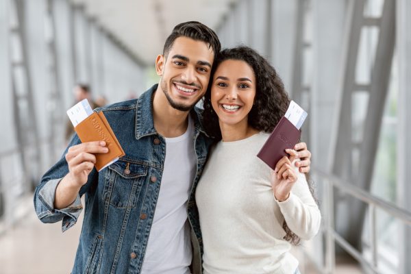 Happy Travellers. Portrait Of Young Arab Couple With Passports And Tickets Posing At Airport, Cheerful Smiling Middle Eastern Spouses Enjoying Travelling Together, Ready For Vacation Trip, Closeup